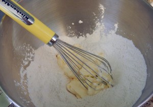Use a whisk or fork when cutting in the butter.  Basically, smush it into the flour without over mixing.